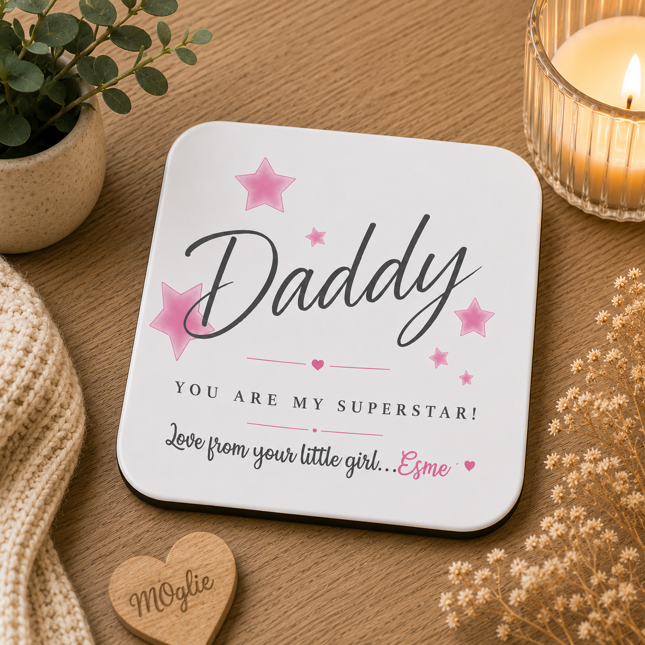 Coaster with 'Daddy, you are my superstar! Love from your little girl...' text on a wooden surface with decorative items.
