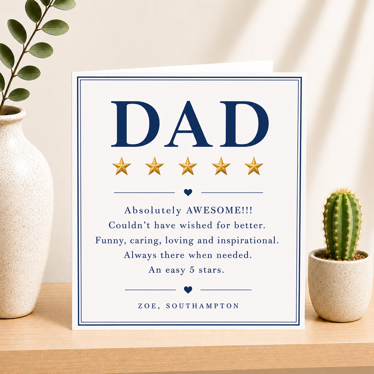 Card with 'DAD' and five-star rating on a table with plants