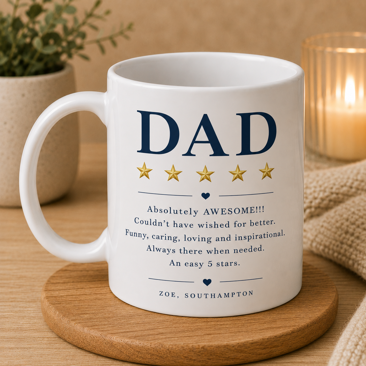 White mug with 'DAD' and five-star rating text on a wooden coaster with a candle and plant in the background.