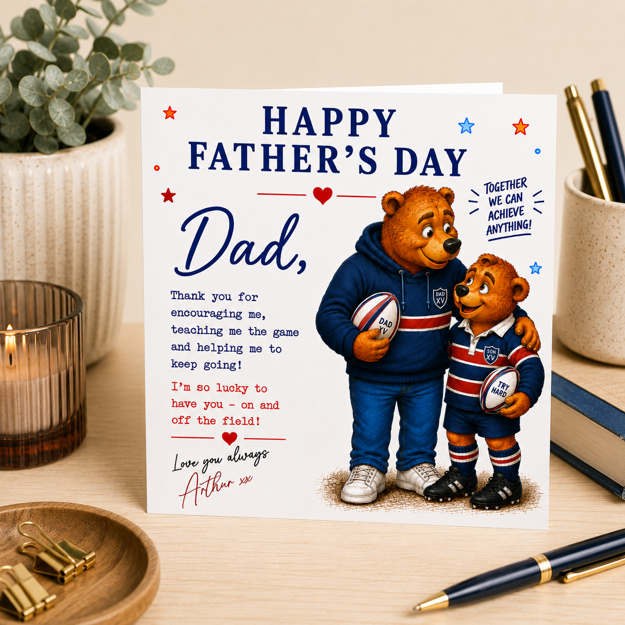Father's Day card with two bears holding rugby balls on a desk with stationery items.