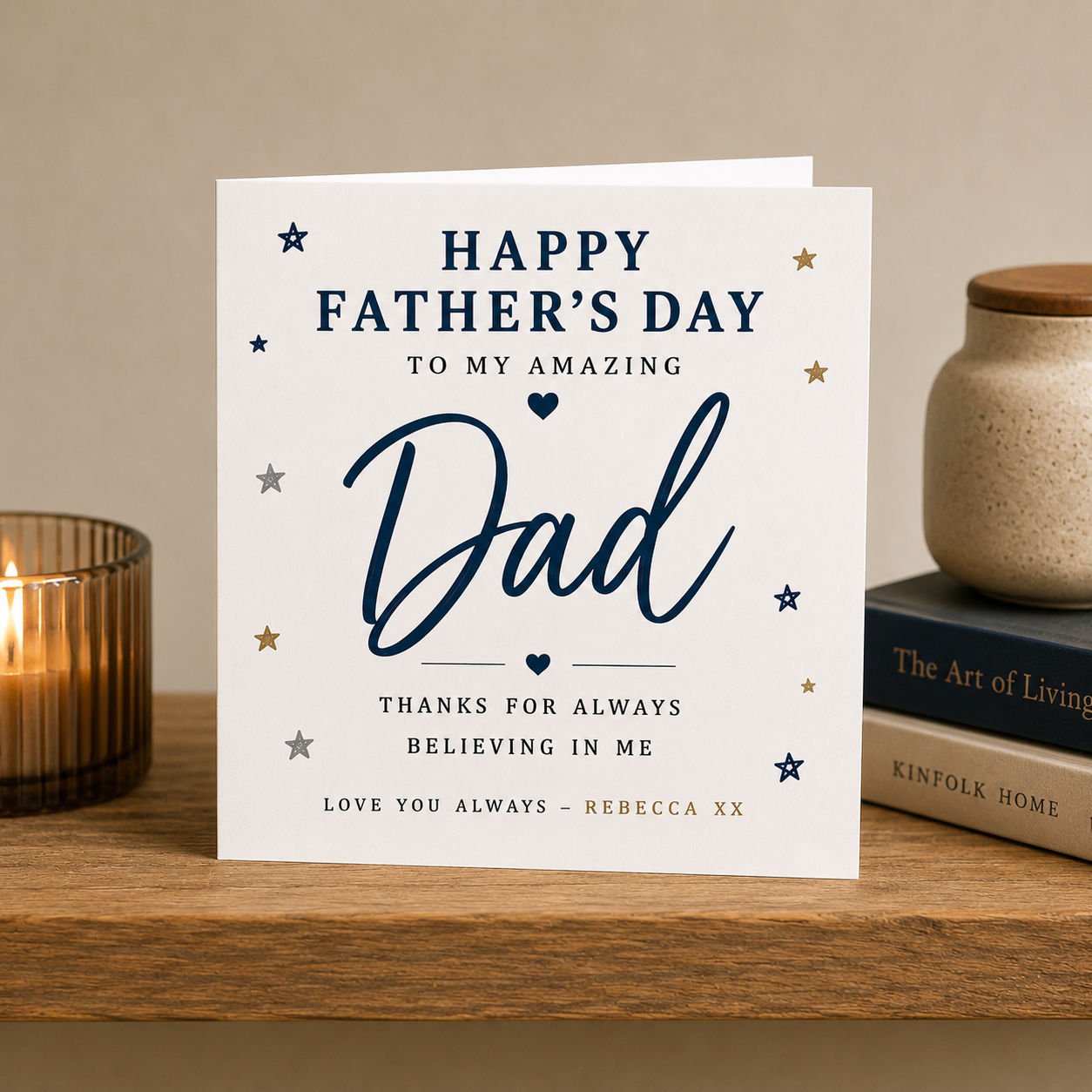 Father's Day card on a wooden surface with books and a candle.